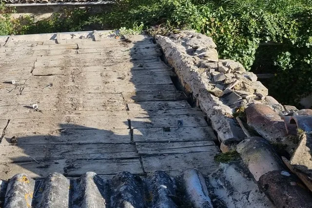 Pan de toiture dont les tuiles ont été déposées, laissant l'ancien support à nu