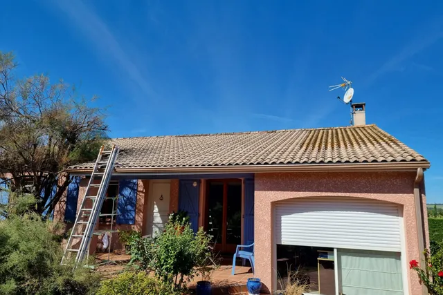 Maison de plain-pied au toit de tuiles terni par les mousses